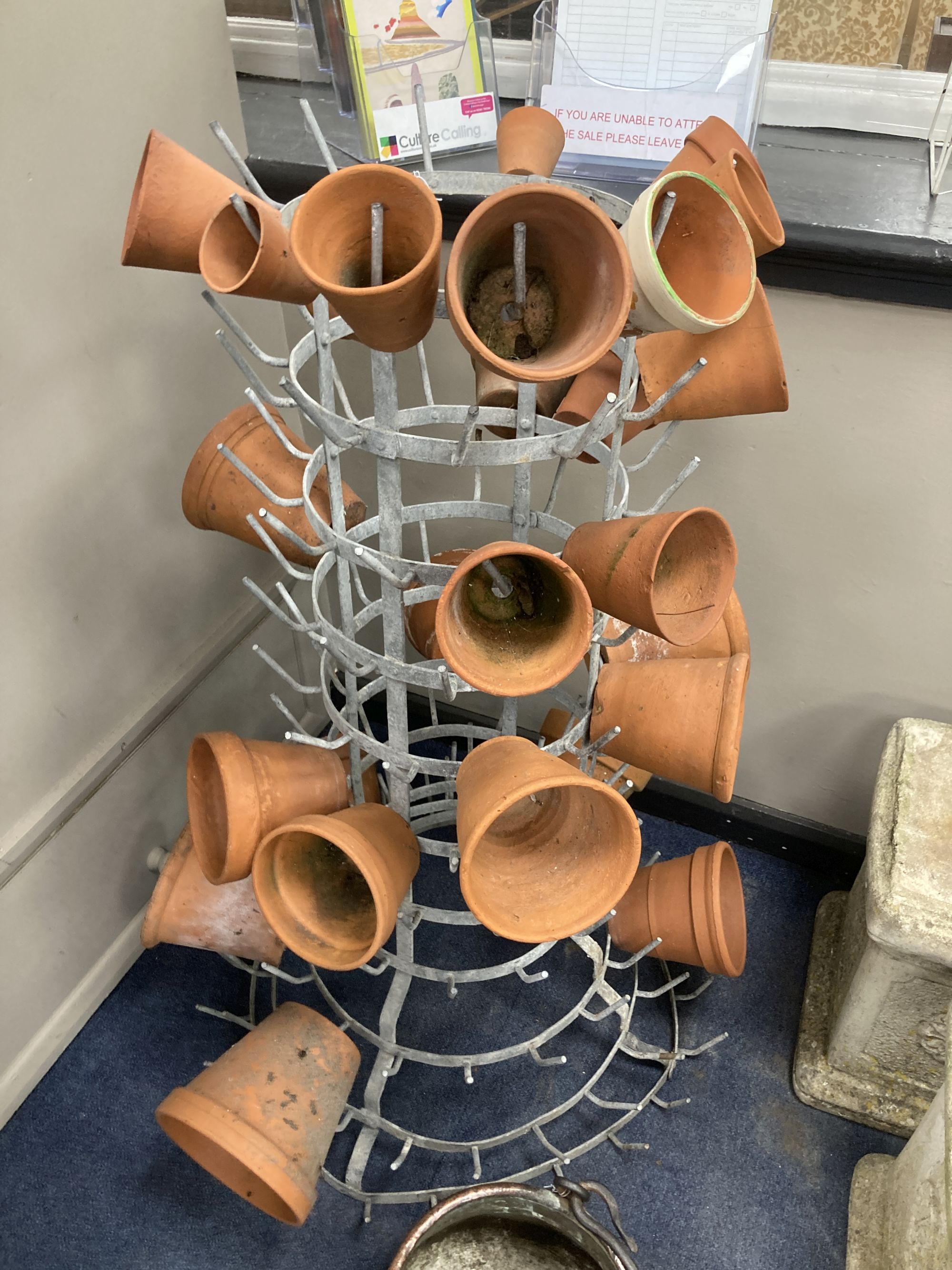 A French metal terracotta pot holder, height 102cm with assorted terracotta pots and an Eastern copper pan, height 21cm